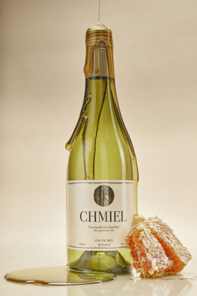 Fotografía dinámica de producto de vino de miel con panal, capturada por RUMA Estudio, Uruguay.