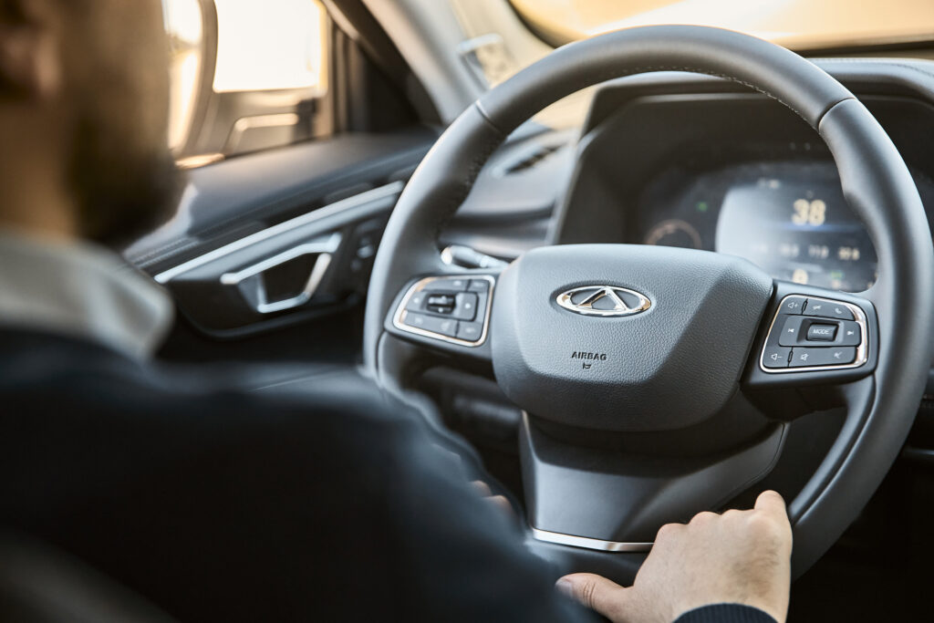Man driving a Chery Tiggo M7 SUV interior, close-up of steering wheel and dashboard – photographed by Mathias Alvez, RUMA Estudio, Uruguay.